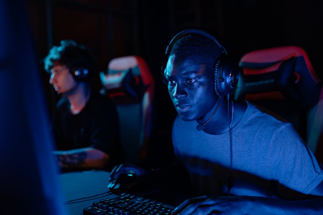 Close-Up Photo of a Man Playing Near a Blue Light