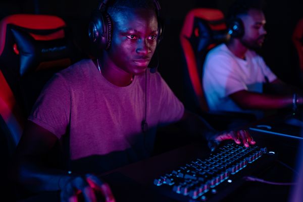 Photo by Yan Krukau on Pexels — a streamer in a headset at a neon-lit desk
