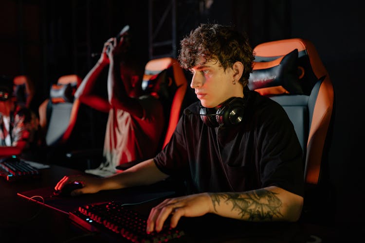 A Man In Black Shirt Using A Computer