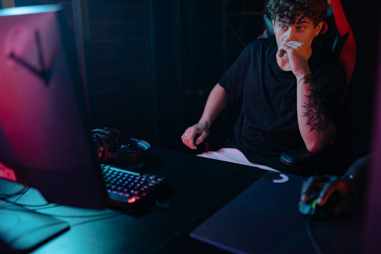 A Man In Black Shirt Using A Computer