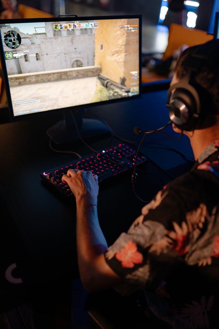 A Man In A Floral Shirt Gaming On A Desktop