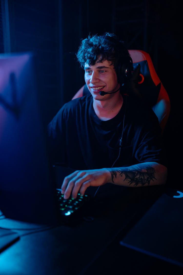 A Man In Black Shirt Playing Video Games On Computer