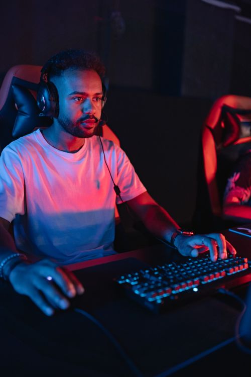 Free A dedicated gamer using a headset and keyboard during an intense online tournament. Stock Photo