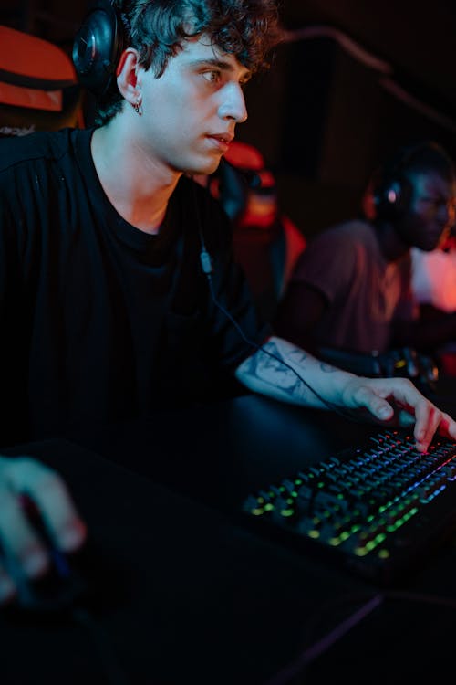 A Gamer in Black Crew Neck T-shirt Using a Black Keyboard