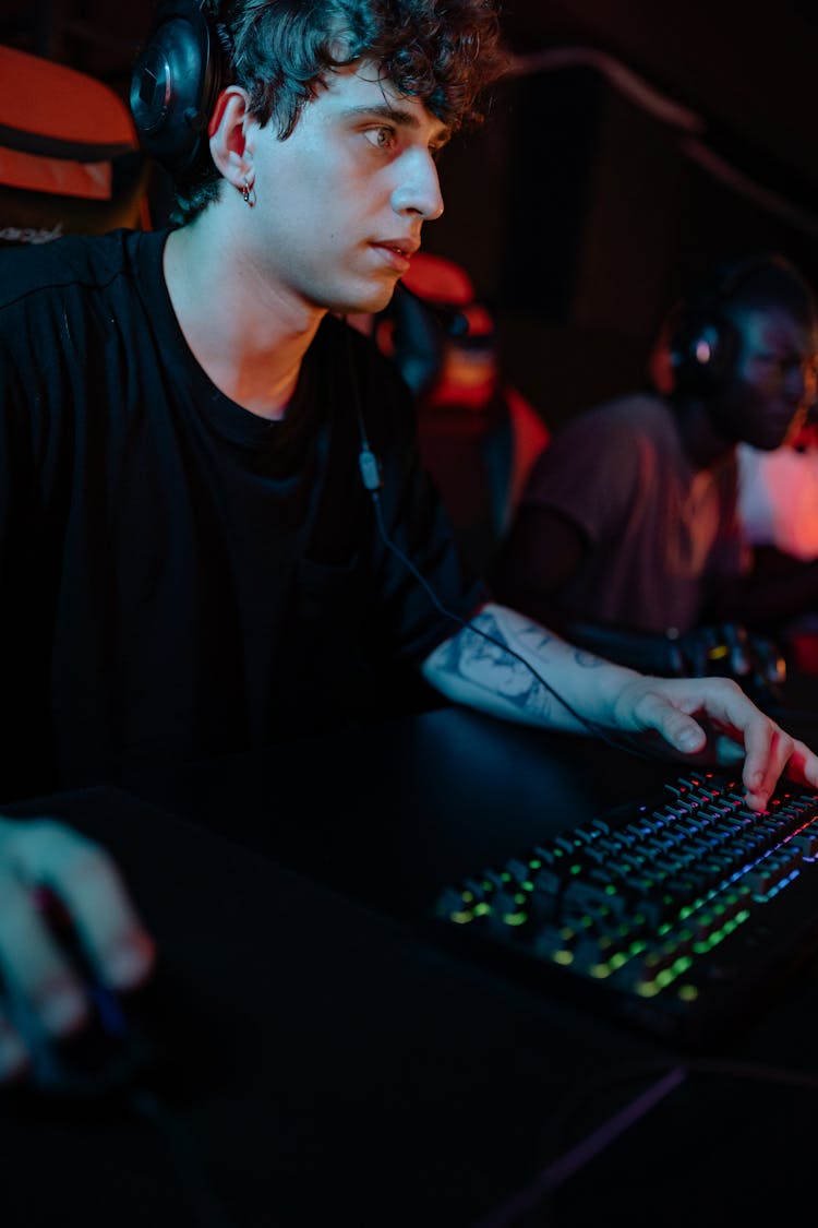 A Gamer In Black Crew Neck T-shirt Using A Black Keyboard