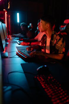 Gamers in a stylish esports café illuminated by vibrant blue and red neon lights.