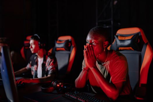 Two gamers intensely focused during an esports event, seated with gaming equipment.