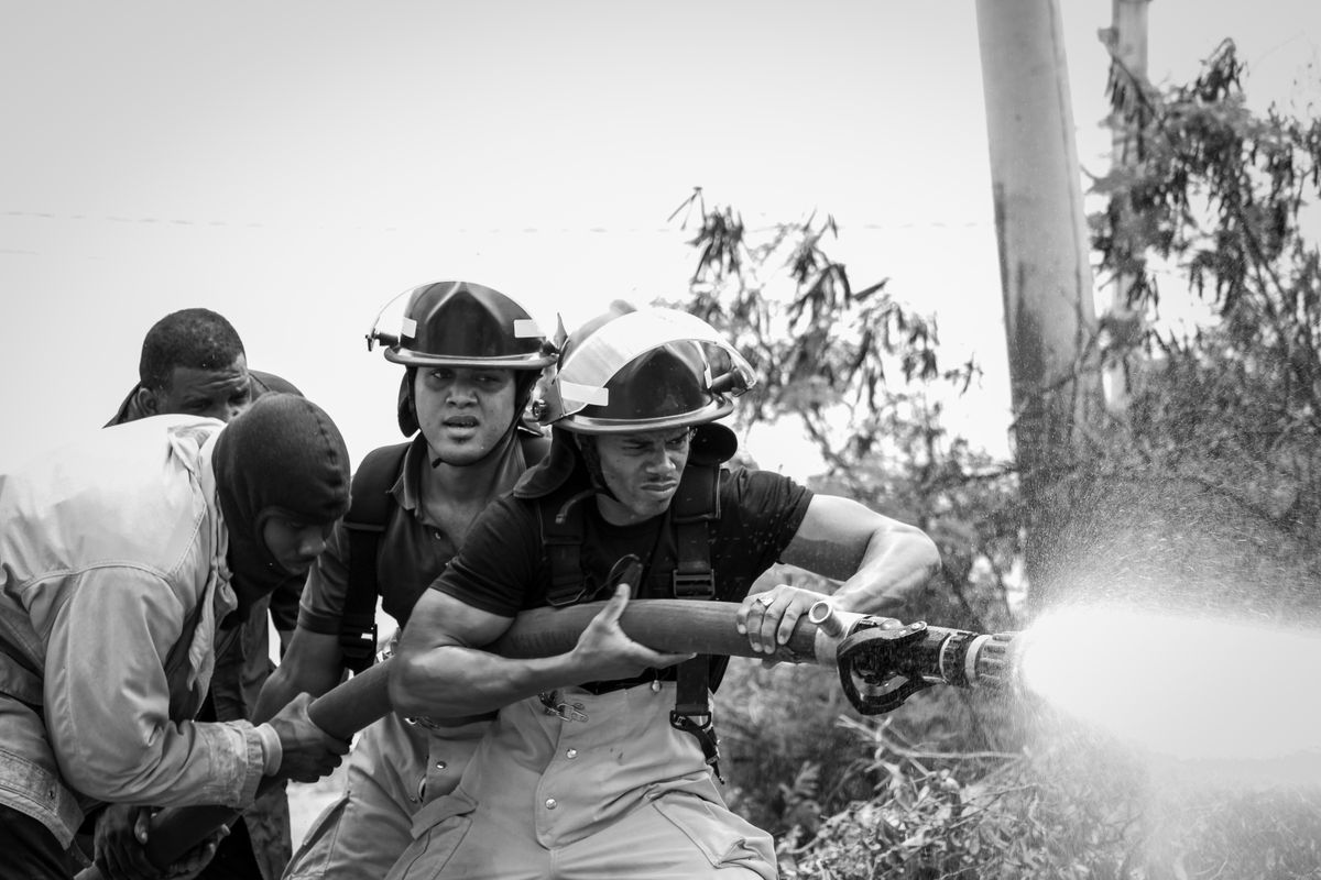 Imagen de archivo de un equipo de bomberos sujetando una manguera