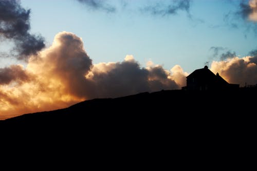 Silhouette of Mountain Under the Cloudy Sky