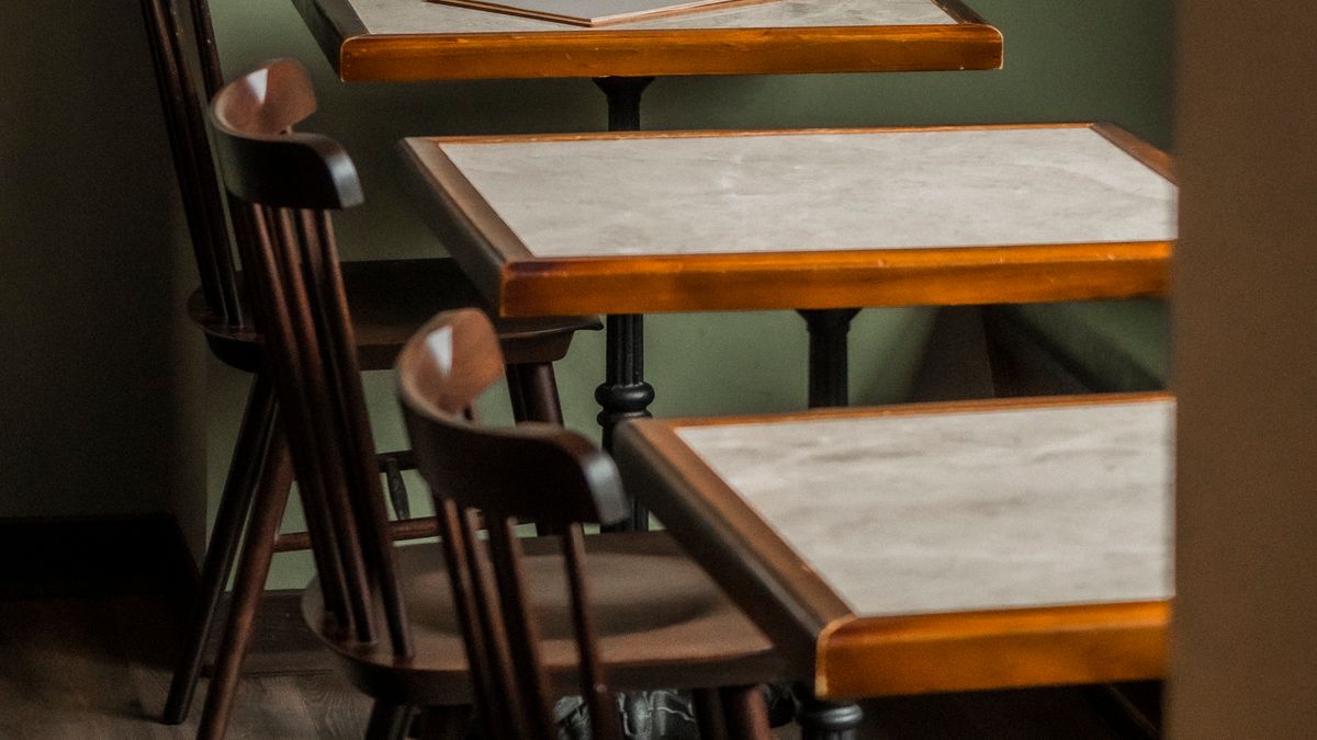 Tables et chaises vides dans un coin de café. Photographie d’illustration.