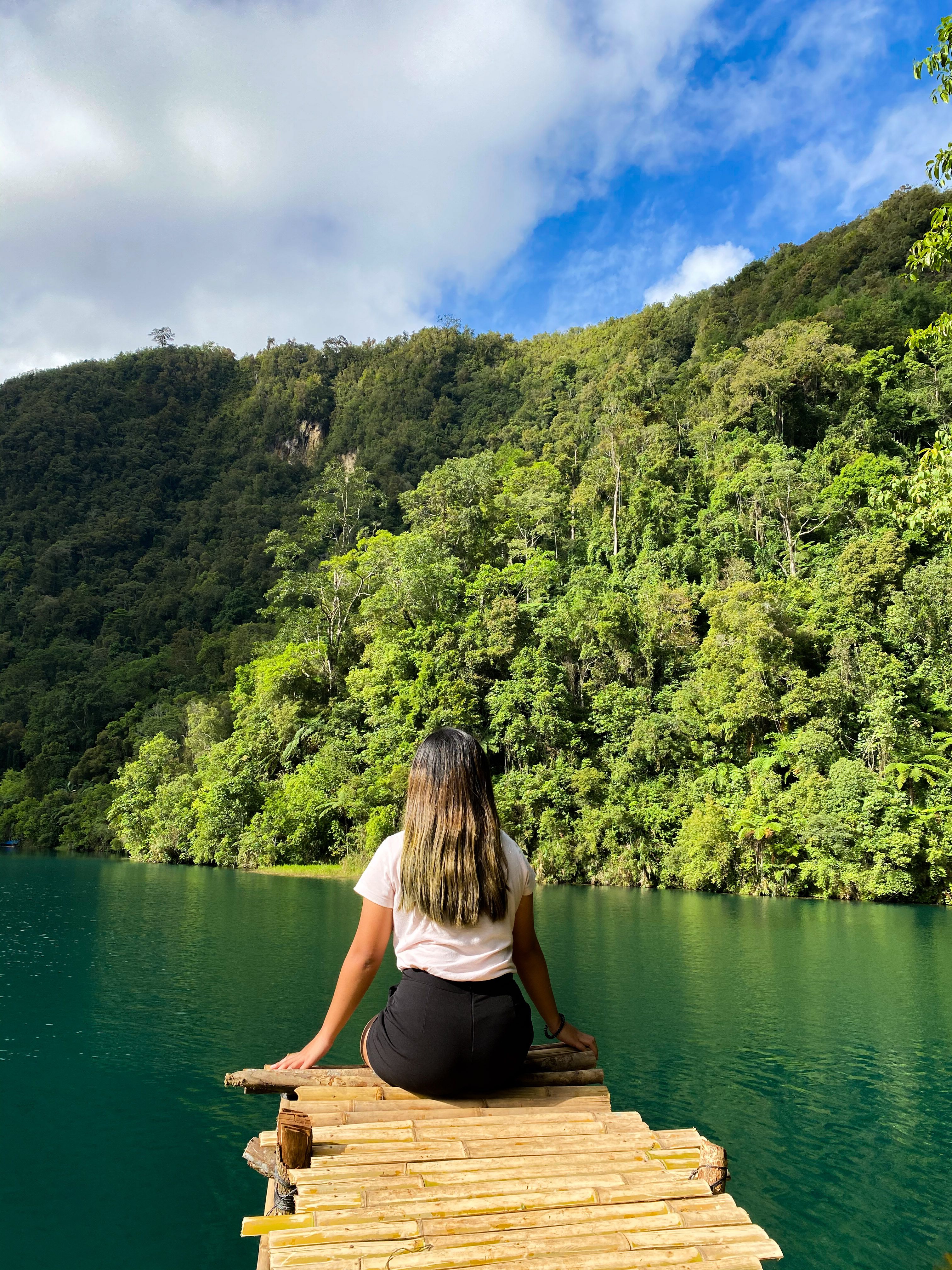 A Woman Sitting on the Edge of a Wooden Dock · Free Stock Photo