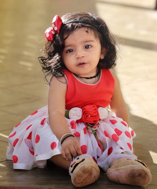 Baby Girl Wearing Polka Dot Dress Sitting on the Floor