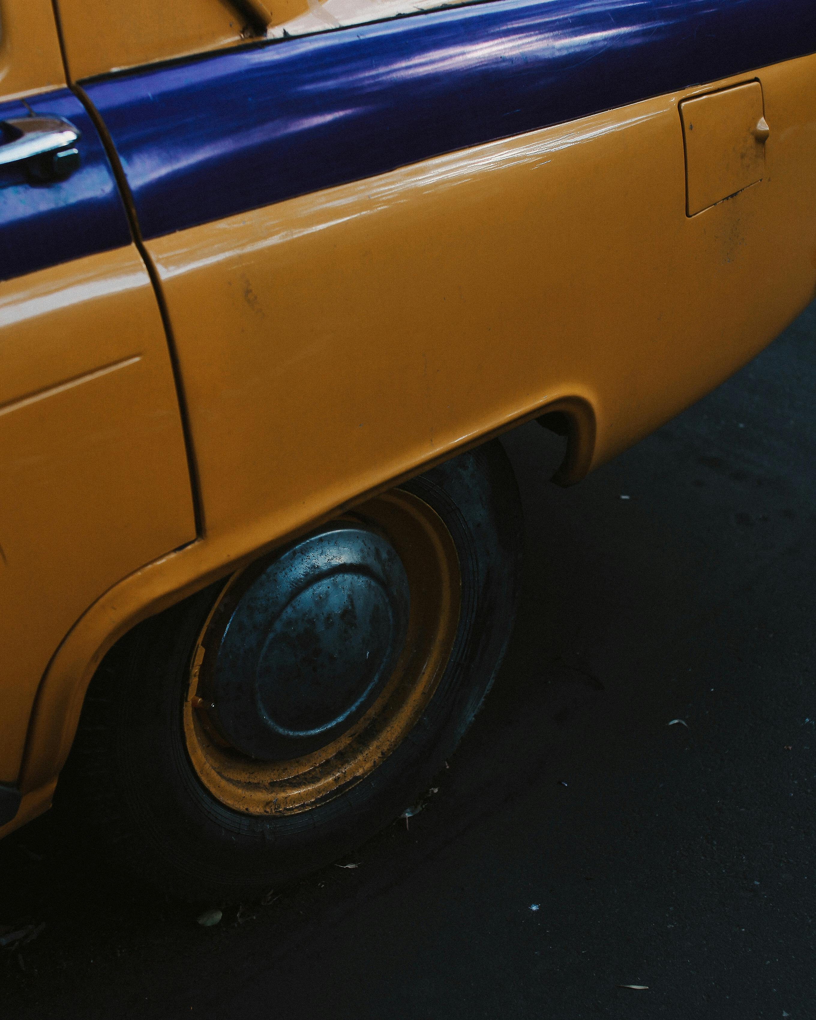 Free Detailed view of a yellow taxi's side with a vibrant color contrast and retro design. Stock Photo