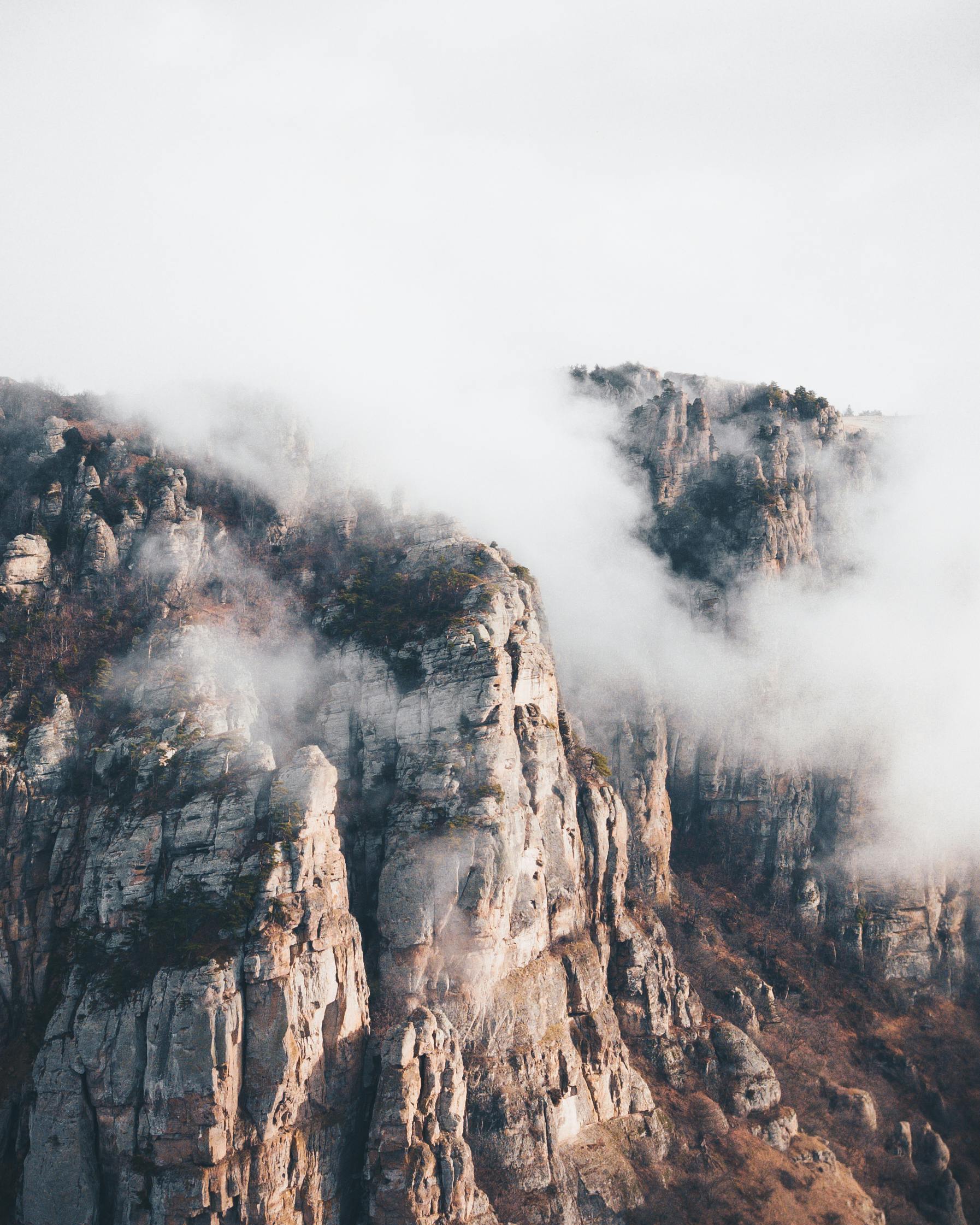 Dramatic mountain peaks partially obscured by clouds, capturing nature's grandeur.