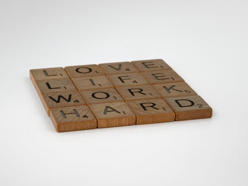 Close-Up Shot of Scrabble Tiles on a White Surface