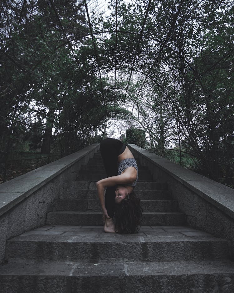 Woman Doing Stretching Exercise On The Stairs