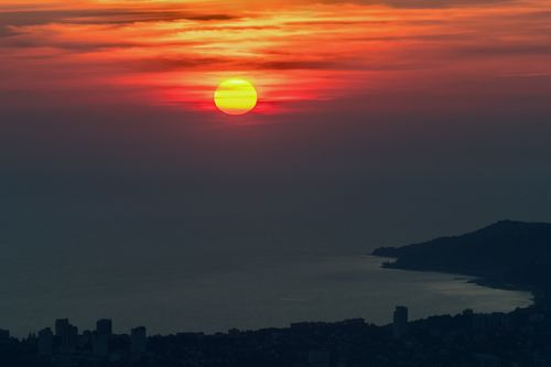 Free Vibrant sunset over Sochi's coastline with a dramatic sky and calm sea. Stock Photo