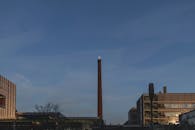 黄昏时分，满月映照下，埃因霍温的标志性工业天际线展现出其现代建筑风貌