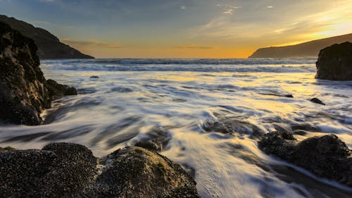 Rock Formation Surrounded by Seawater during Sunset