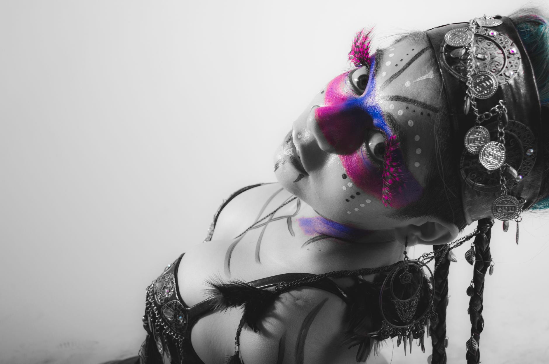 Artistic portrait of a woman with intricate face paint and jewelry.