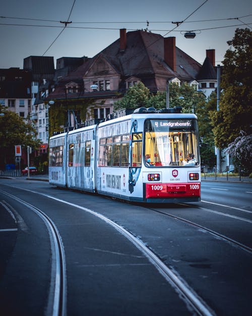 White Tram on Railway Beside a Road