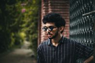 Man in Black and White Plaid Button Up Shirt Wearing Black Sunglasses