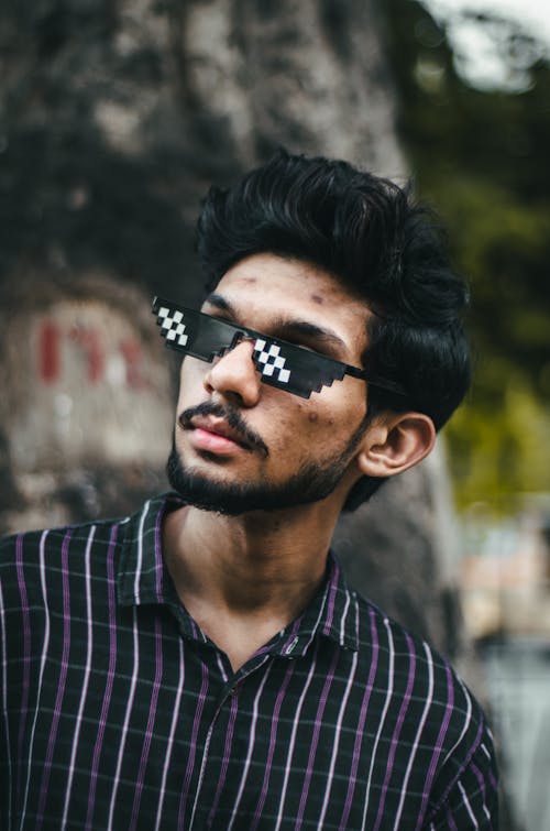 Man in Checkered Button Up Shirt Wearing Black Sunglasses