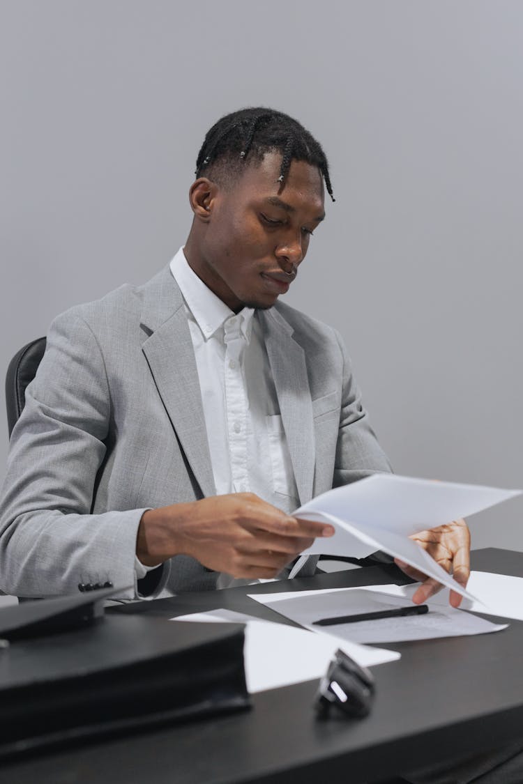 A Man In Gray Suit Holding Papers