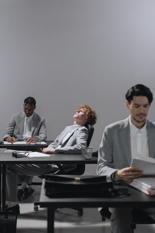 Free Professionals in office experiencing work fatigue, highlighting burnout. Stock Photo