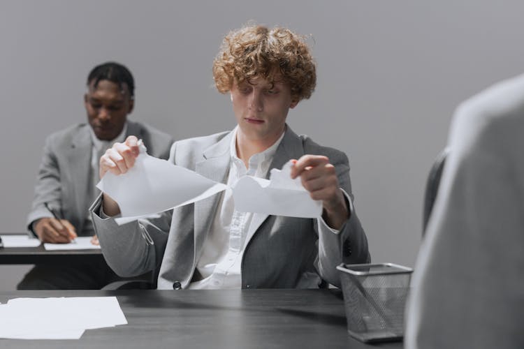 A Man In Gray Suit Tearing A Paper