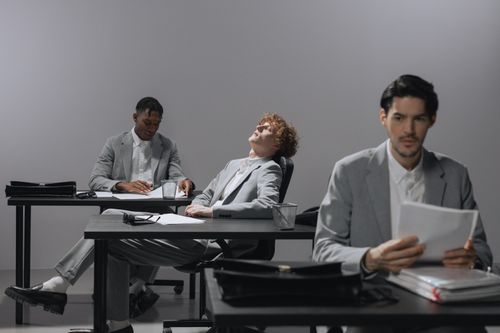Free Professionals in gray suits engage in a business meeting at an office. Stock Photo