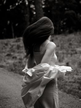 Artistic black and white portrait of a woman in motion captured outdoors, expressing freedom and grace.