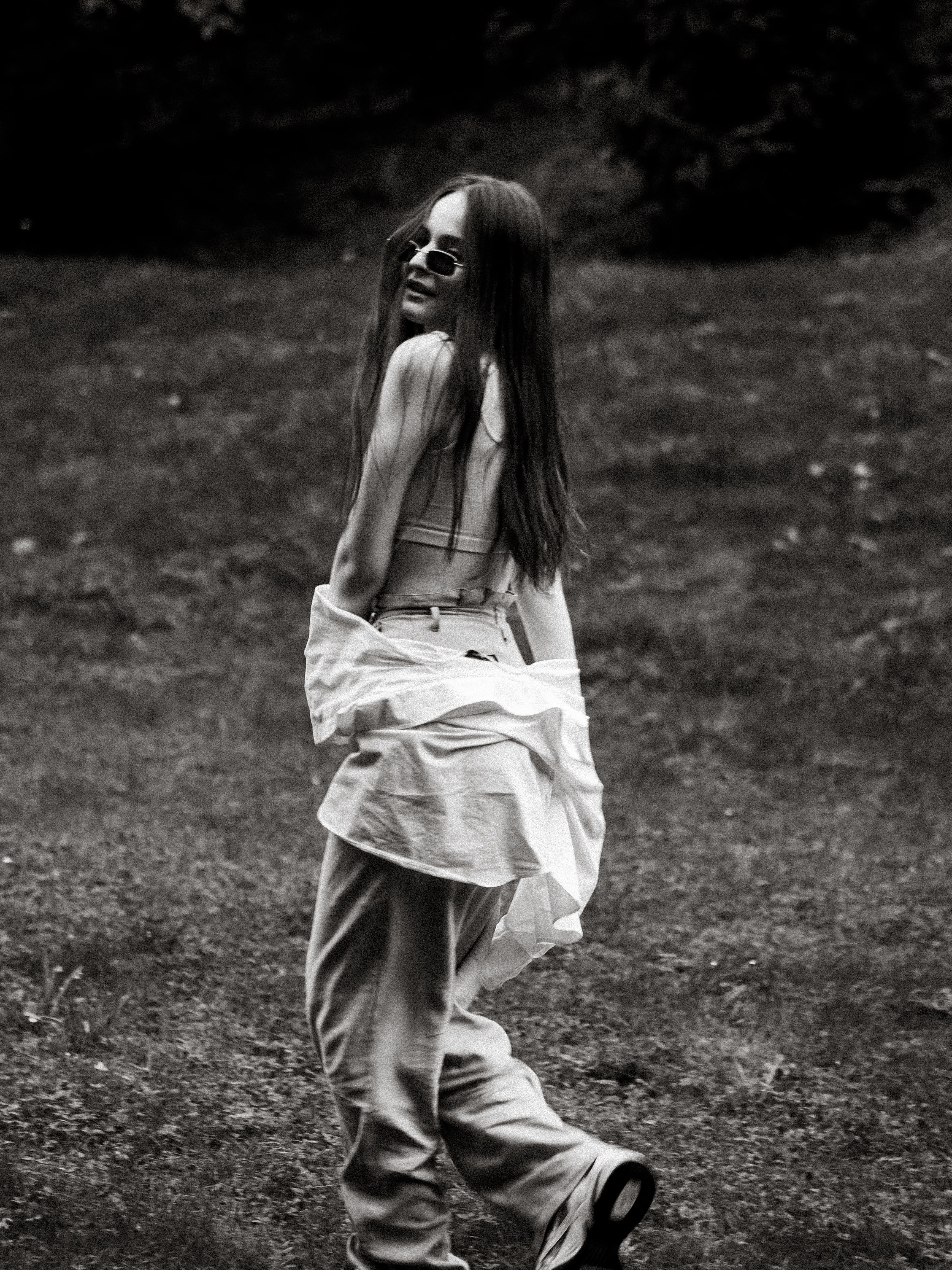 A Grayscale Photo of a Woman Walking on the Field · Free Stock Photo
