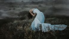 Woman in White Dress Standing on Brown Grass Field