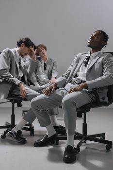 Group of diverse men in corporate attire relaxing in an office environment.