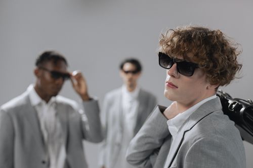 Free Group of fashionable professional men in gray suits and sunglasses indoors. Stock Photo