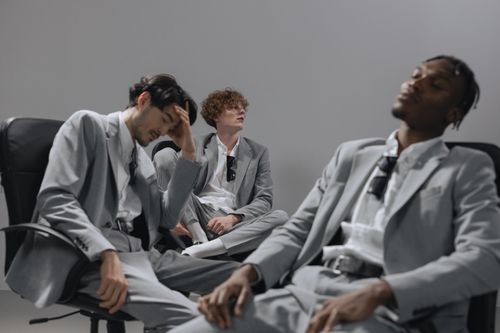 Free A diverse group of office workers in gray suits sitting relaxed in chairs indoors. Stock Photo