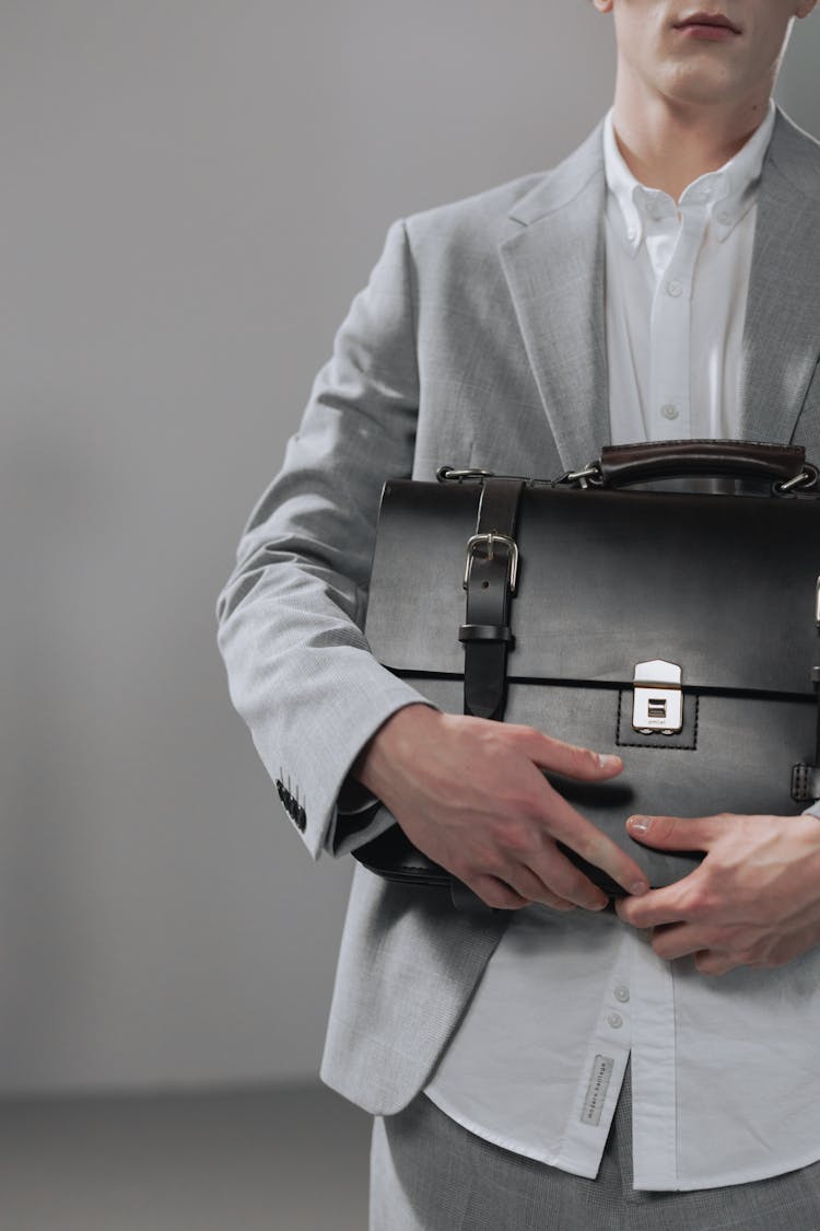 A Man Holding A Black Briefcase