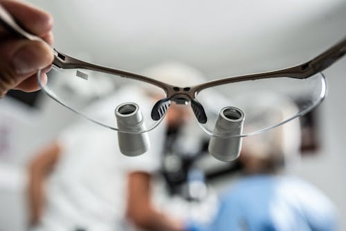 Free A Person Holding a Pair of Dental Loupes Stock Photo