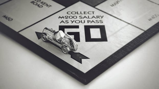 Black and white close-up of a Monopoly car piece on the board game.
