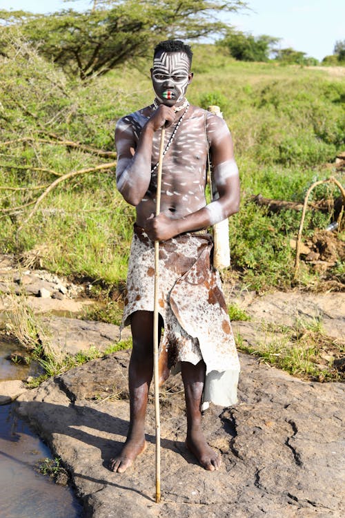 Man Wearing Animal Skin Clothing and Having His Body Painted 