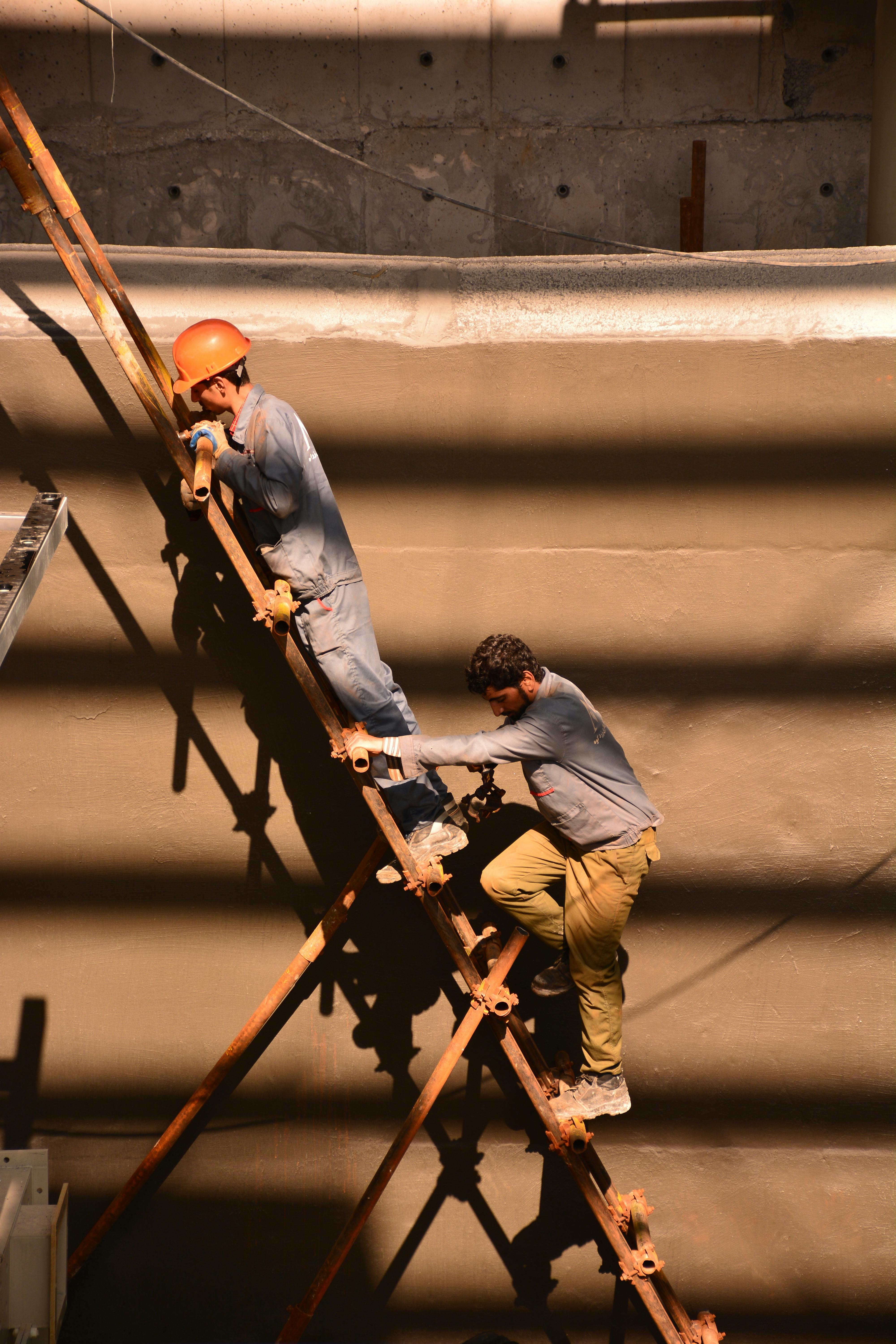 men standing on rusty metal ladder