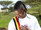 Man in outdoor setting wearing a shirt with national colors, touching his heart with respect.