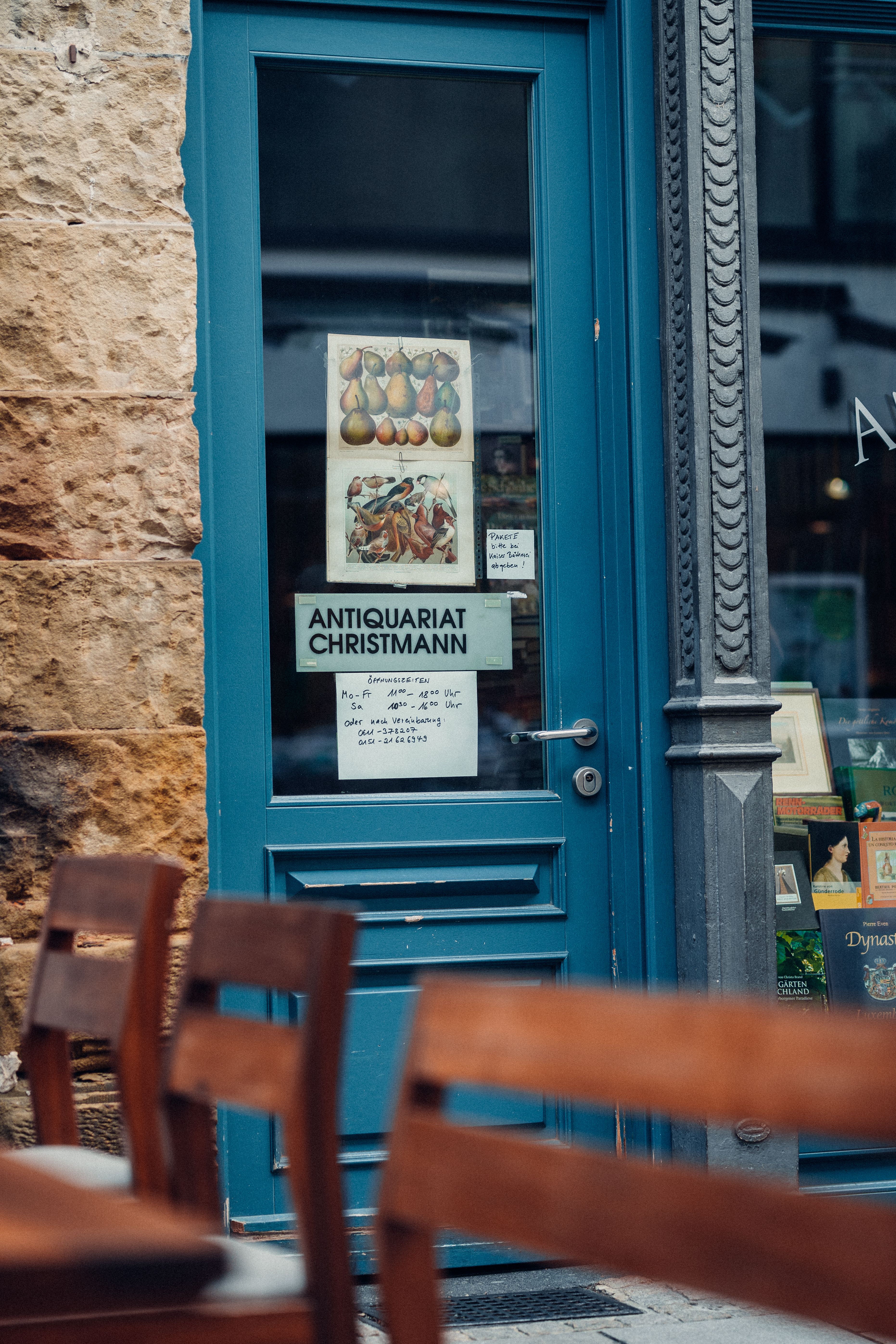 A cozy bookstore entrance with a blue door in Wiesbaden, Germany, featuring antique posters.