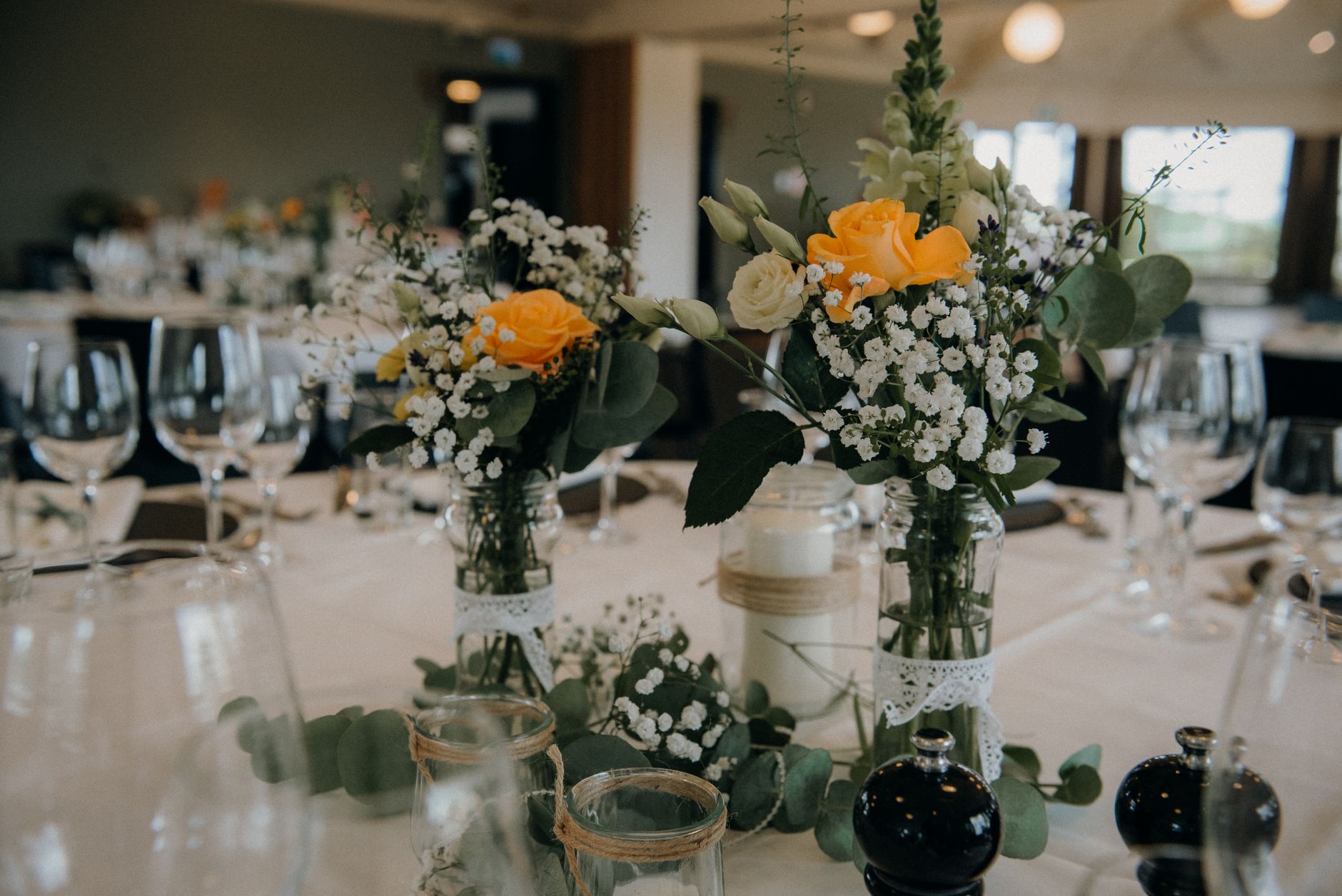 Elegant restaurant table setup featuring floral centerpieces and glassware, perfect for weddings or events.