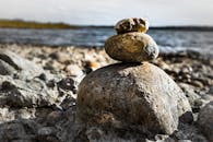 特写镜头聚焦在多岩石湖岸上堆叠的石头，展现宁静与平衡