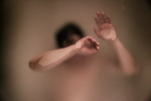 雾玻璃后的人影抽象而朦胧，唤起一种孤独与内省的主题