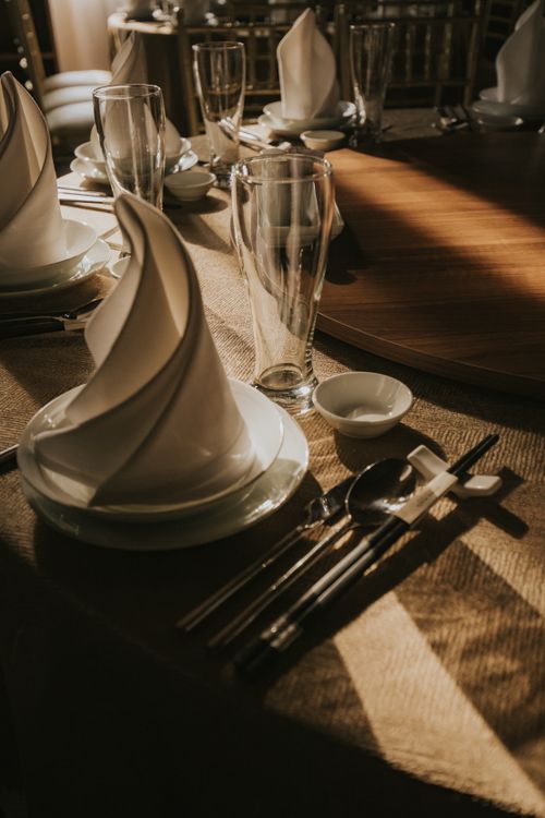 Free Elegant dining table arrangement featuring glassware and neatly folded napkins in soft lighting. Stock Photo