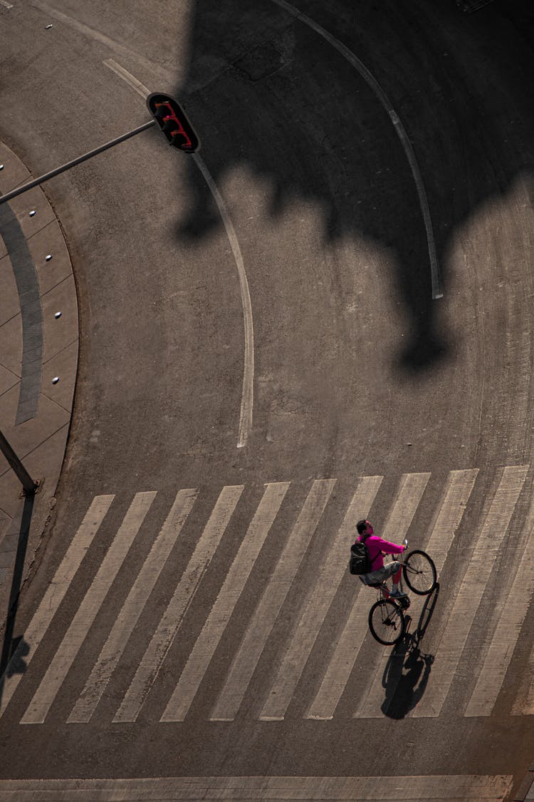 An Aerial Photography Of A Person Riding A Bike On The Road