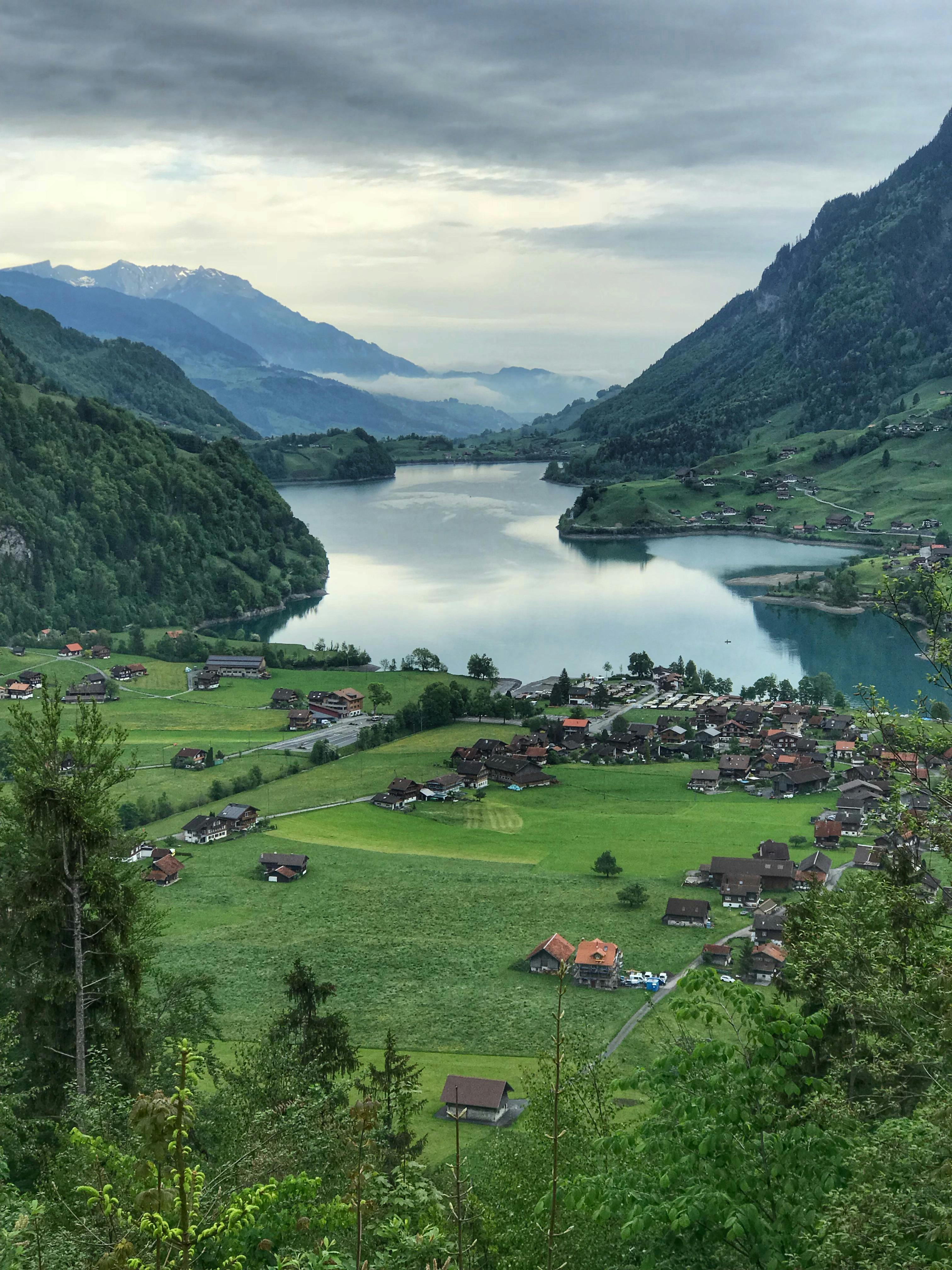 A beautiful aerial view of Lauterbrunnen Valley with a lake, mountains, and lush greenery.